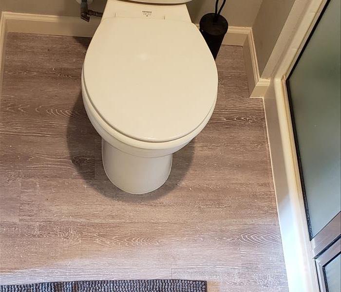 Master bath flooring is replaced and toilet is reset.
